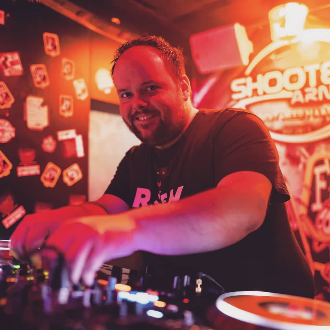 DJ Markza op het podium tijdens een festival met publiek en sfeerverlichting