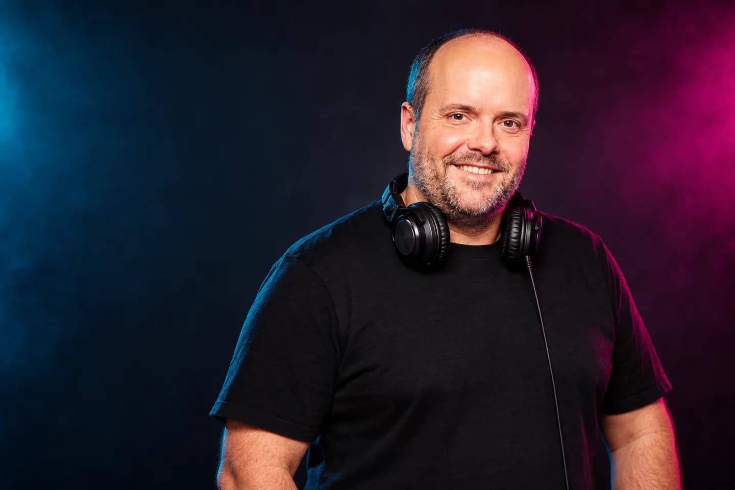 DJ Markza met een koptelefoon in een donker verlichte studio